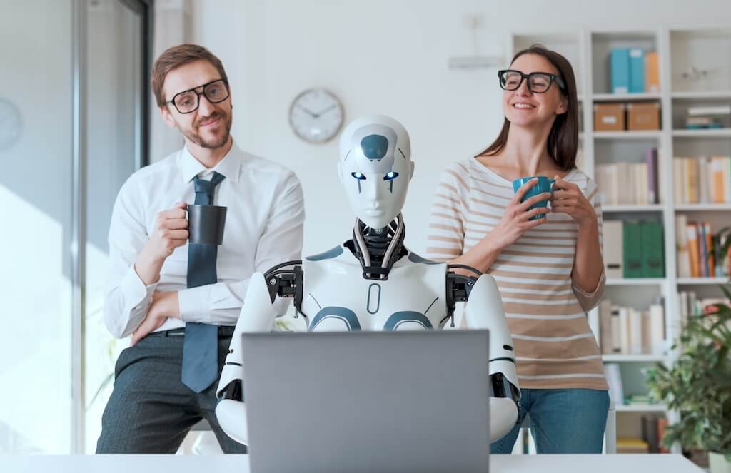 Egy robot laptopnál ül két felnőtt mellett, ami az "AI Chatbotok Forradalma az Angol Nyelvtanulásban" elemzést idézi.