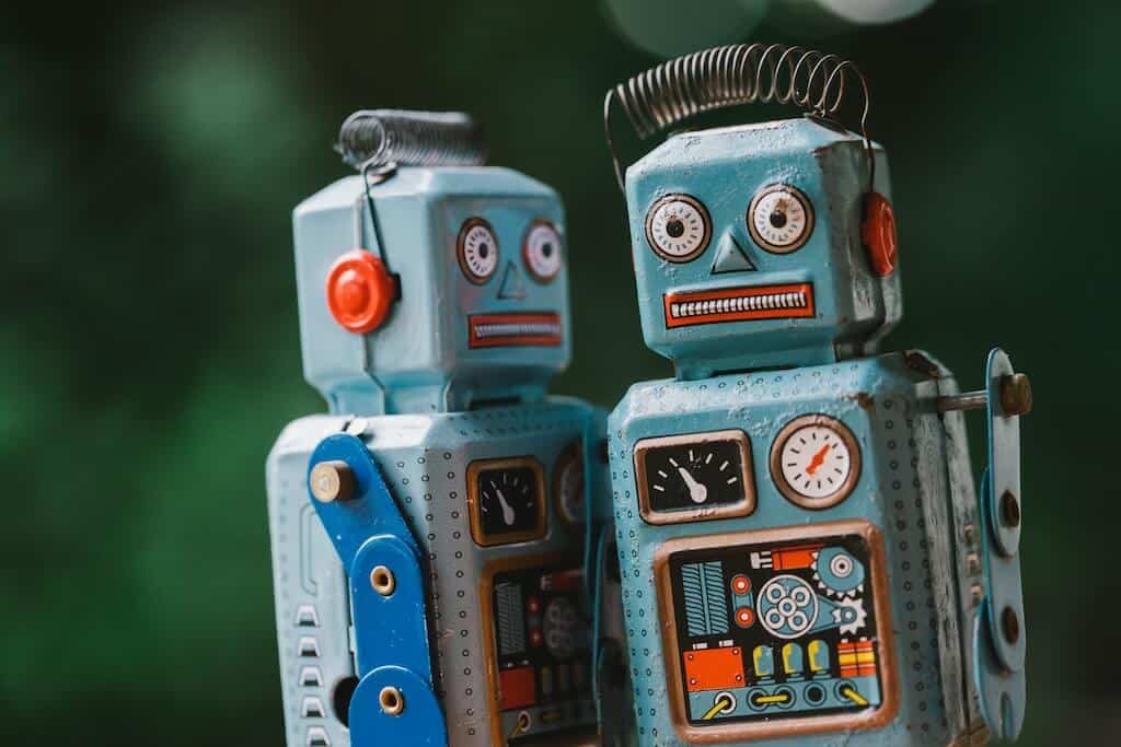 Két retró robot látható, ami az AI Chatbotok Forradalma az Angol Nyelvtanulásban elemzés üzleti angol fókuszát idézi.